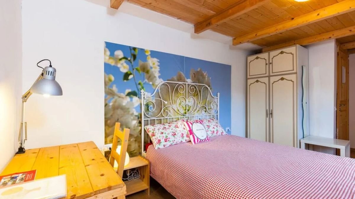 Camera il Sognatore, letto con testata in ferro battuto e murale floreale